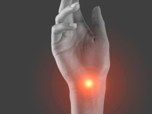 Hand with a glowing red point of pain at the wrist