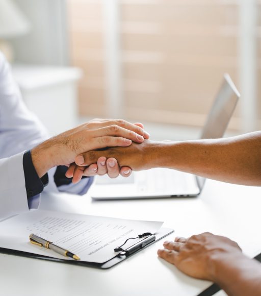 Doctor holding a patient's hand during a consultation